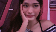 a woman with her hand on her face looks at the camera