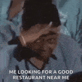 a man is covering his face with his hand while looking for a good restaurant near him .