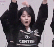 a woman wearing a black center shirt is raising her arms in the air