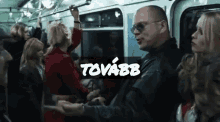 a group of people on a subway train with the word tovarb on the bottom