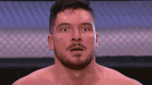 a shirtless man with a beard looks surprised