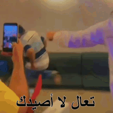 a person is taking a picture of a man dancing with arabic writing on it