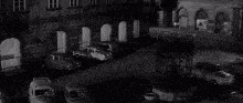 a black and white photo of a car with the reflection of a person in the rear view mirror .