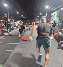 a man is running in a gym with the letter m behind him