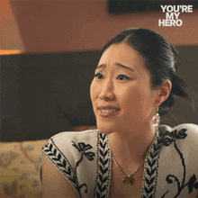 a woman sitting on a couch with the words " you 're my hero " written on the bottom
