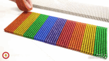 a bunch of colorful beads are lined up on a table