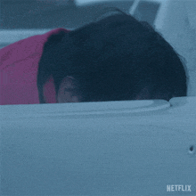 a man in a red jacket is looking out a window with netflix written on the bottom