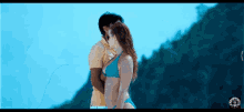 a man and a woman are kissing on the beach