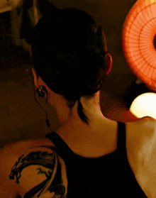 a woman has a tattoo of a dragon on her shoulder