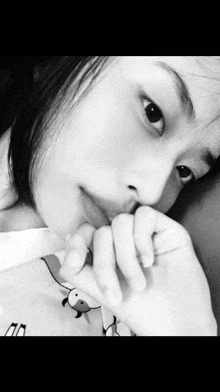 a black and white photo of a young girl with her hand on her face