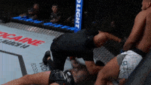 a fighter is laying on the ground in a cage with a sign that says bud light