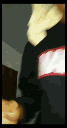 a blurry picture of a person wearing a black shirt with a red supreme logo