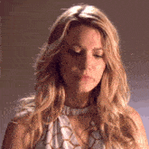 a close up of a woman 's face with her eyes closed and her hair blowing in the wind