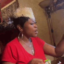 a woman in a red shirt is sitting in a chair in a living room .