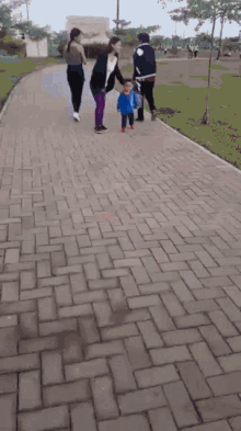 a blurry picture of a little boy running on a brick road