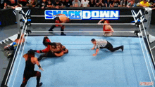 a group of wrestlers are wrestling in a ring with a smack down sign in the background