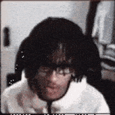 a man with a wig on his head is sitting in a chair with his mouth open .