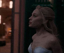 a woman with long blonde hair is wearing a white dress with rhinestones