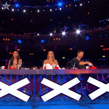 a group of people sitting at a table in front of a xxx sign