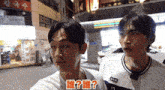 two young men are standing next to each other and one of them has a nyk t-shirt on