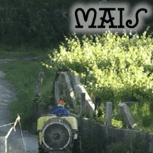 a tractor is driving down a dirt road with the word mais on the bottom