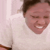 a woman in a white sweater is smiling with her eyes closed and her mouth open .