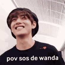 a young man wearing a hat and a t-shirt with the words pov sos de wanda written on it .