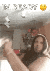 a woman is making a funny face in a kitchen while wearing headphones and a hoodie .
