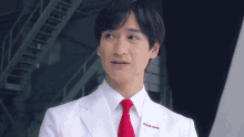 a man in a white lab coat and red tie has the word johnson & johnson embroidered on his chest