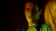 a man in a green shirt looks at a woman