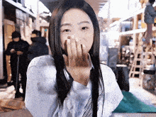 a girl with long hair covering her mouth with her hand and the name jiffae on the bottom right
