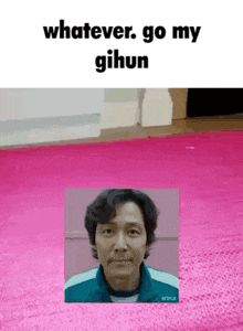 a man is standing in front of a pink rug with the words `` whatever go my gihun '' written on it .