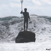 a statue of a man holding a trident is in the ocean