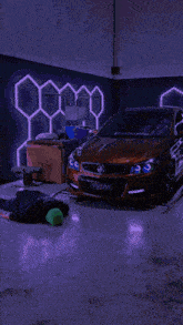 a man is laying on the floor in front of a red car with a license plate that says tpb251