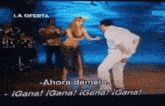 a man and a woman are dancing on a television screen with the words ahora damelo in the corner