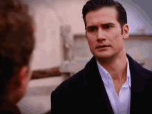 a man in a suit talks to another man