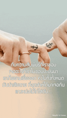 a couple holding hands with an anchor tattoo on their fingers