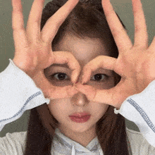 a woman is making a heart with her hands