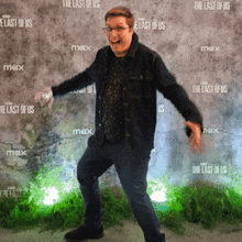 a man stands in front of a wall that has the last of us written on it