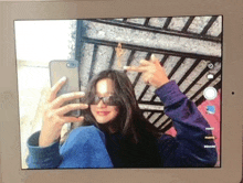 a girl is taking a selfie on a tablet with her phone