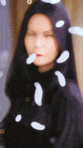 a blurry picture of a woman with white feathers falling on her face