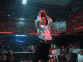 a man in a white shirt and black pants is dancing in front of a crowd
