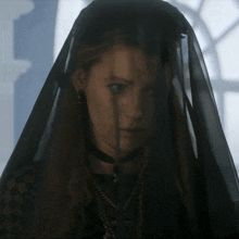a woman wearing a black veil and a choker