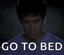 a man in a purple shirt with the words go to bed written on it