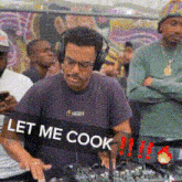 a man wearing headphones is playing music with the words let me cook on the bottom