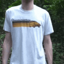 a man wearing a white t-shirt with a picture of a bus on it