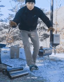 a man wearing a patagonia jacket is standing on one leg