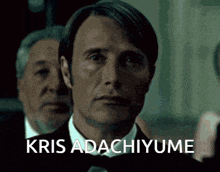 a man in a tuxedo says kris adachiyume in front of another man
