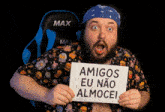 a man holding a sign that says amigos eu não almocei