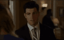 a man in a suit and tie is looking at a woman .